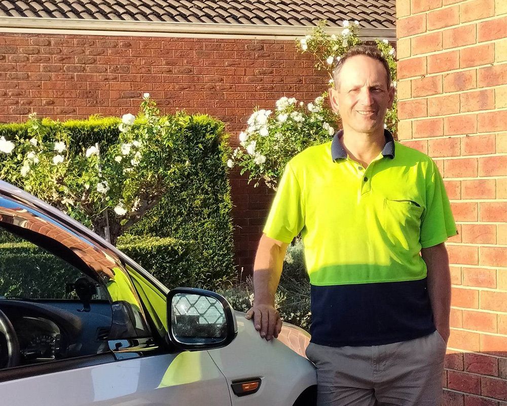 Gardener standing by his car