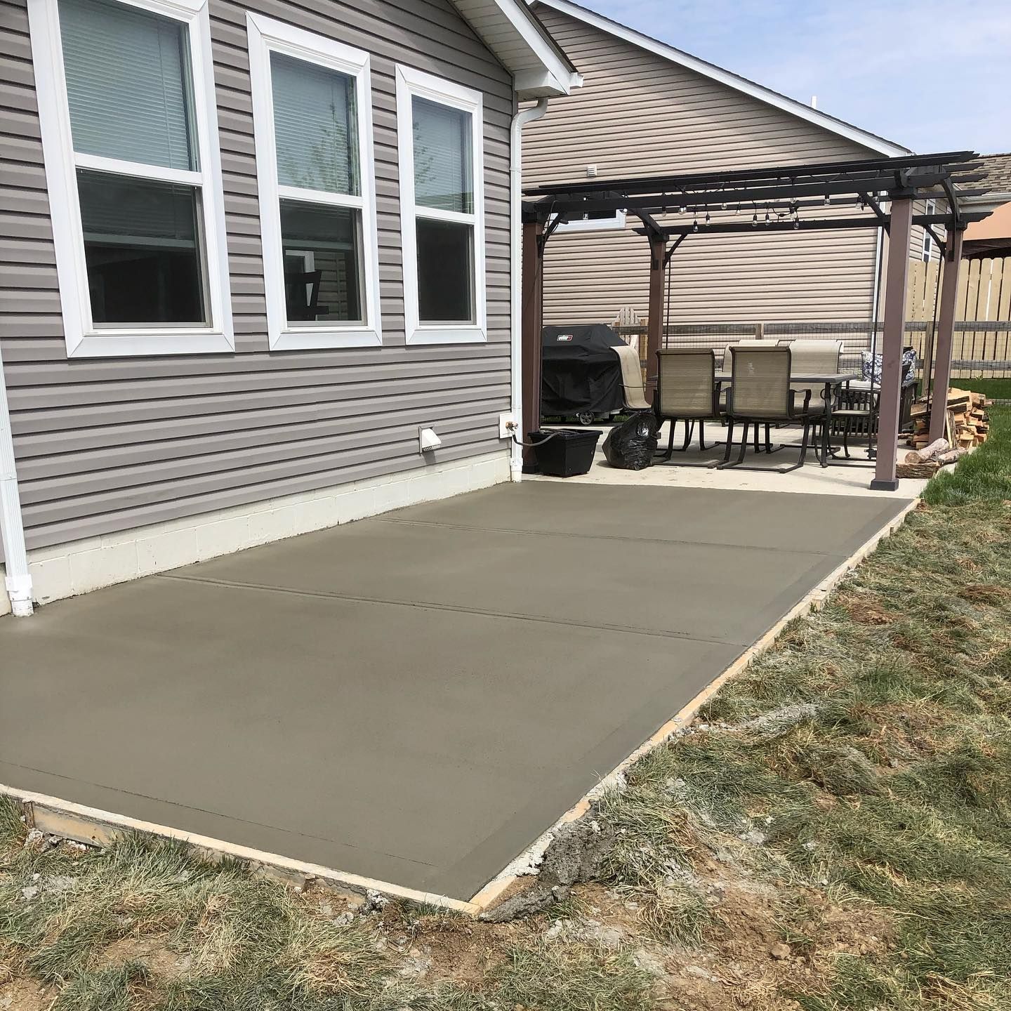 Man digging in an excavated area with a backhoe. Brown earth, orange machinery.