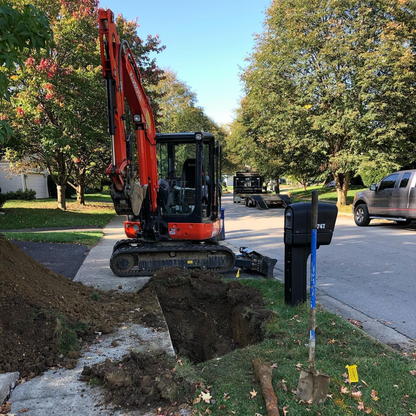 Freshly poured concrete border around a gravel area next to a driveway and landscaping.