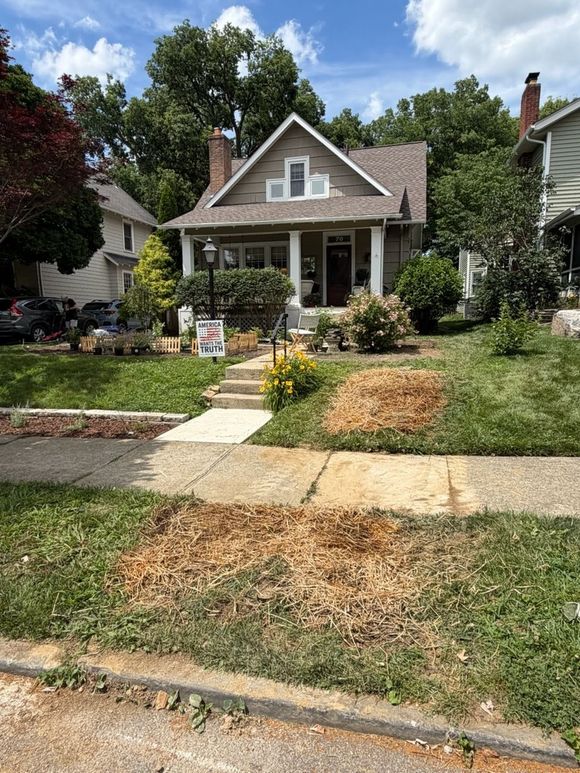 Freshly poured concrete border around a gravel area next to a driveway and landscaping.