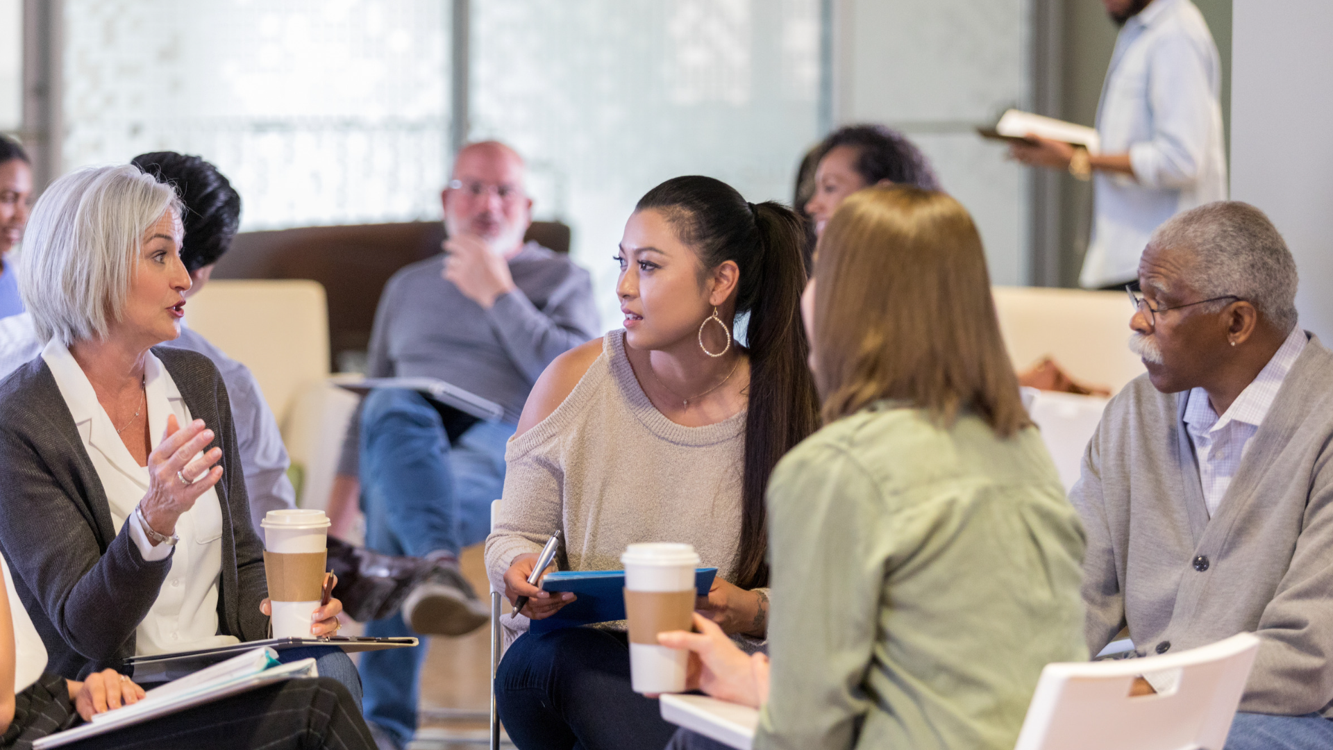 A group of people are sitting around a table having a meeting.