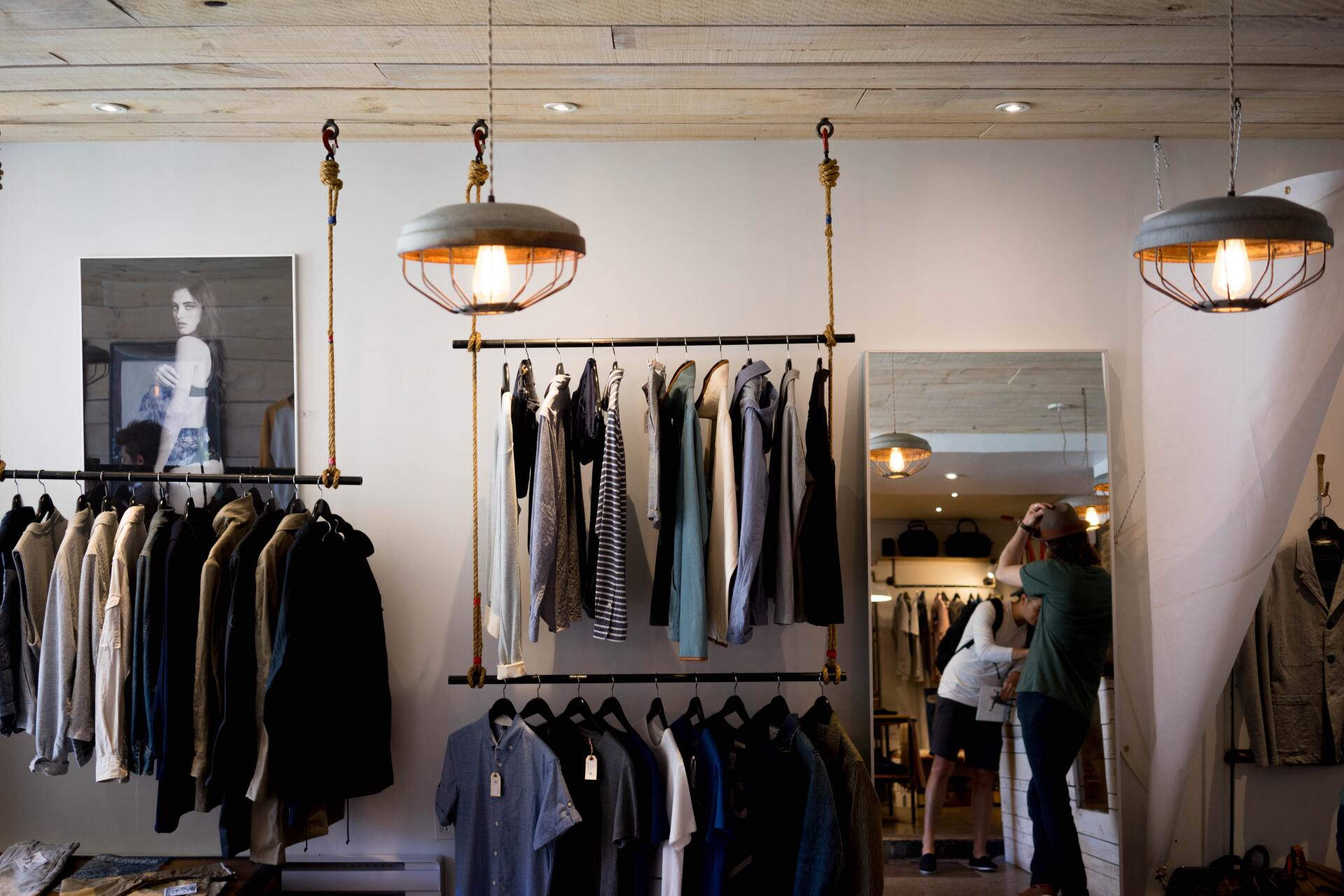 Inside a dimly lit, small clothing store with several racks of jackets and shirt hanging on the rack