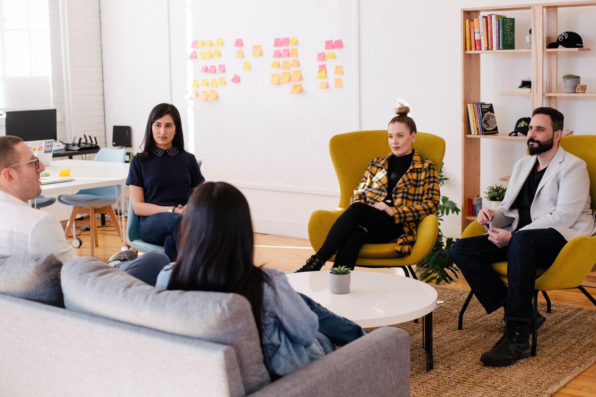 A group of people are sitting around a table in a living room.