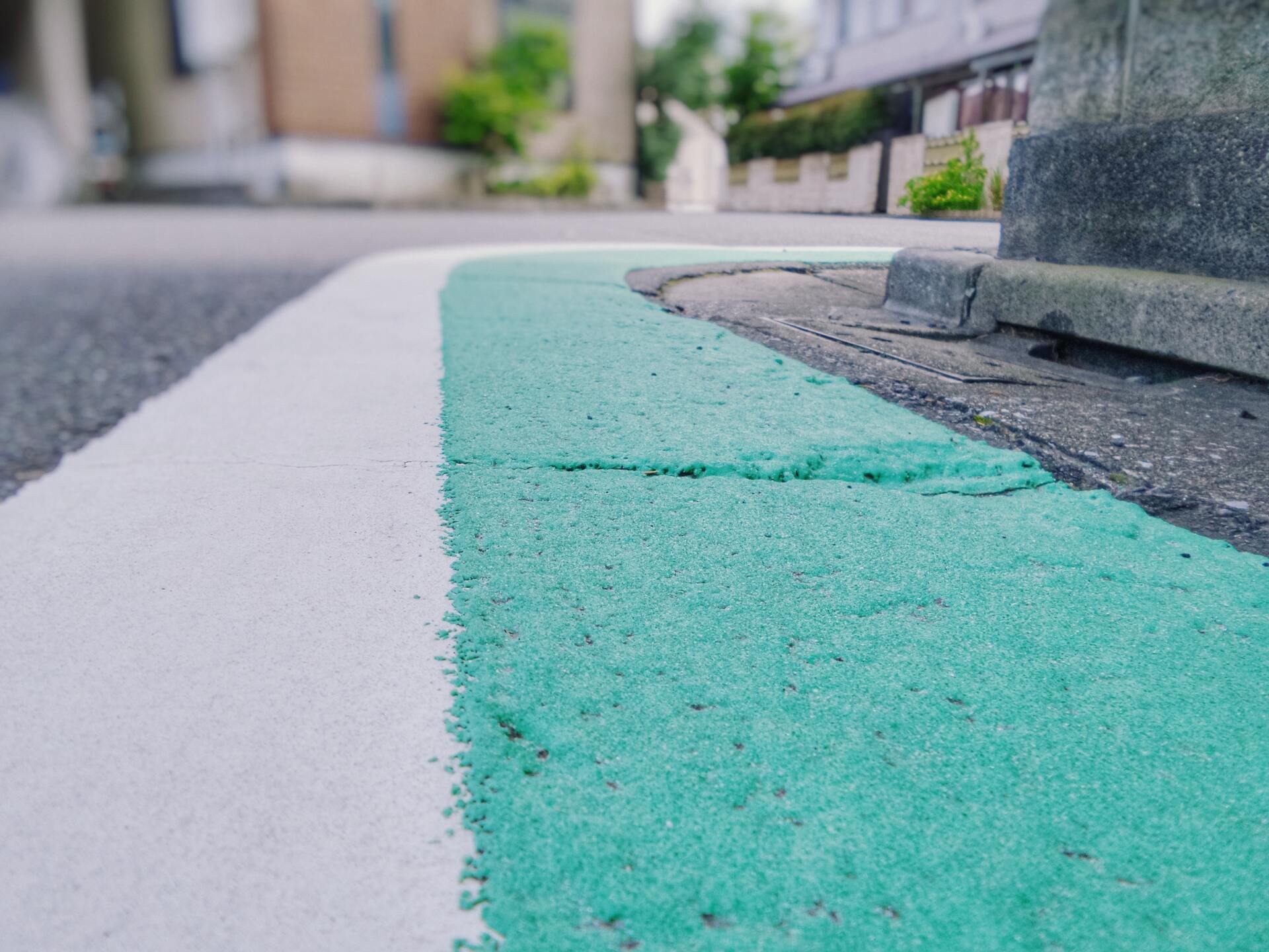 Green and white parking line on a road