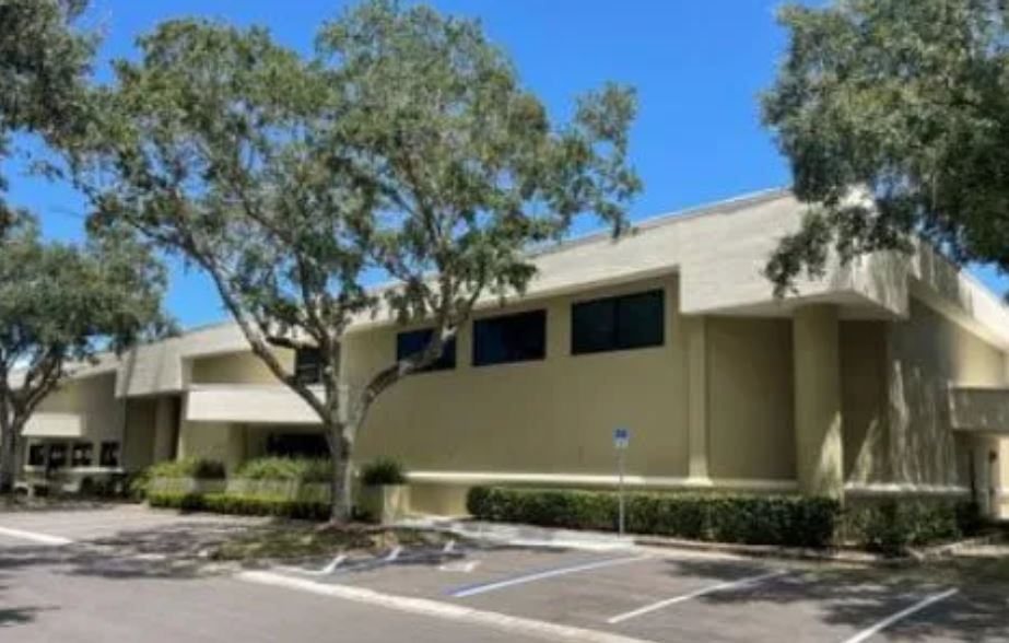 A large building with a parking lot in front of it.