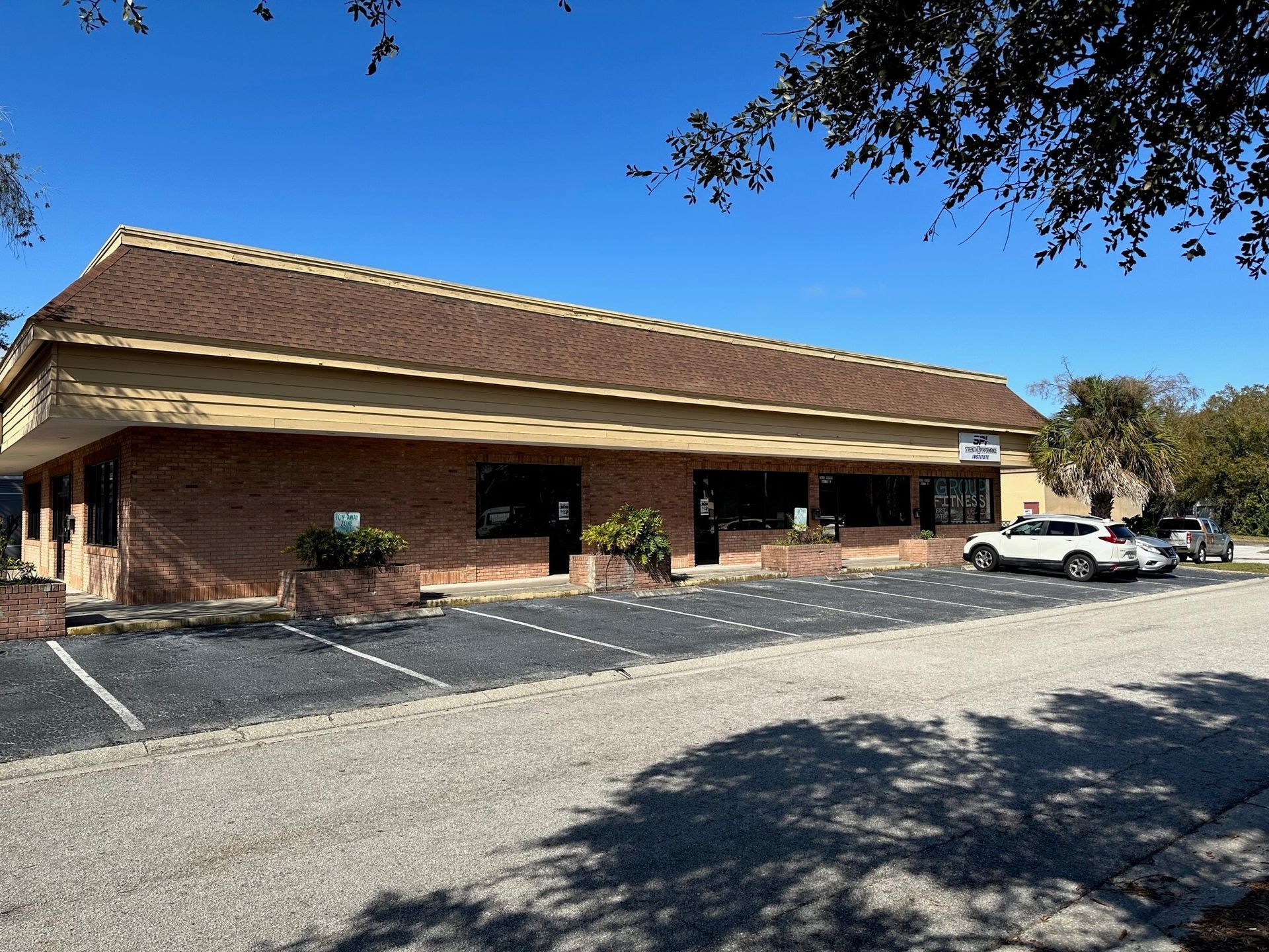 A large brick building with a parking lot in front of it.