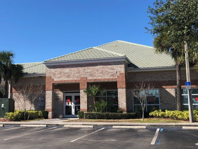 A large brick building with a parking lot in front of it.