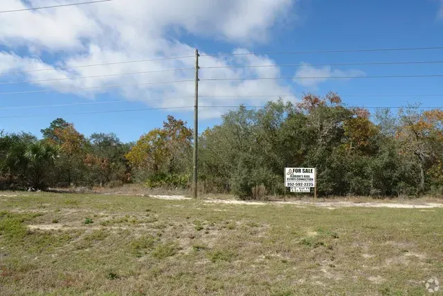 There is a sign in the middle of the field.