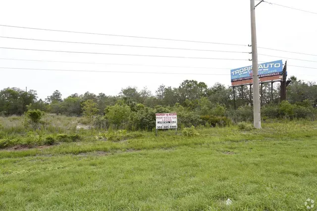 A large grassy field with a billboard in the background.