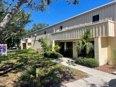 A large building with a for sale sign in front of it.