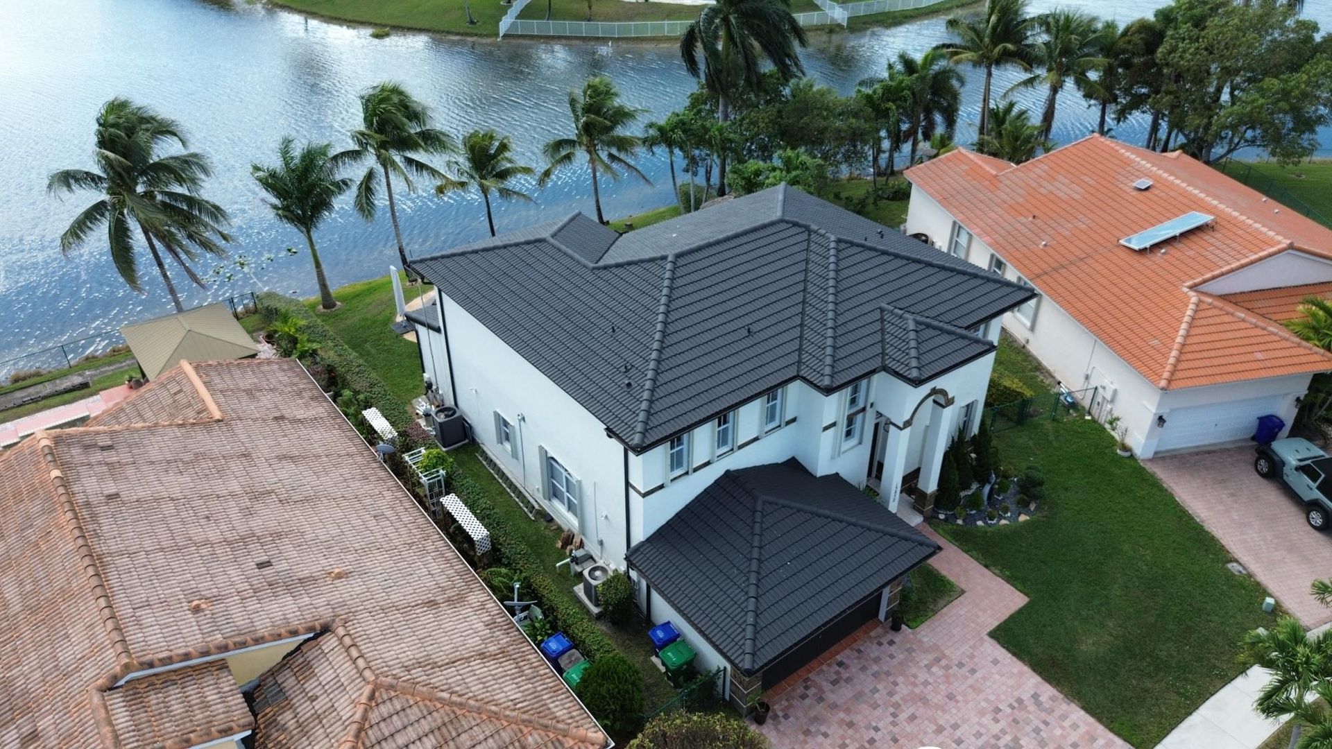 An aerial view of a large white house with a black roof