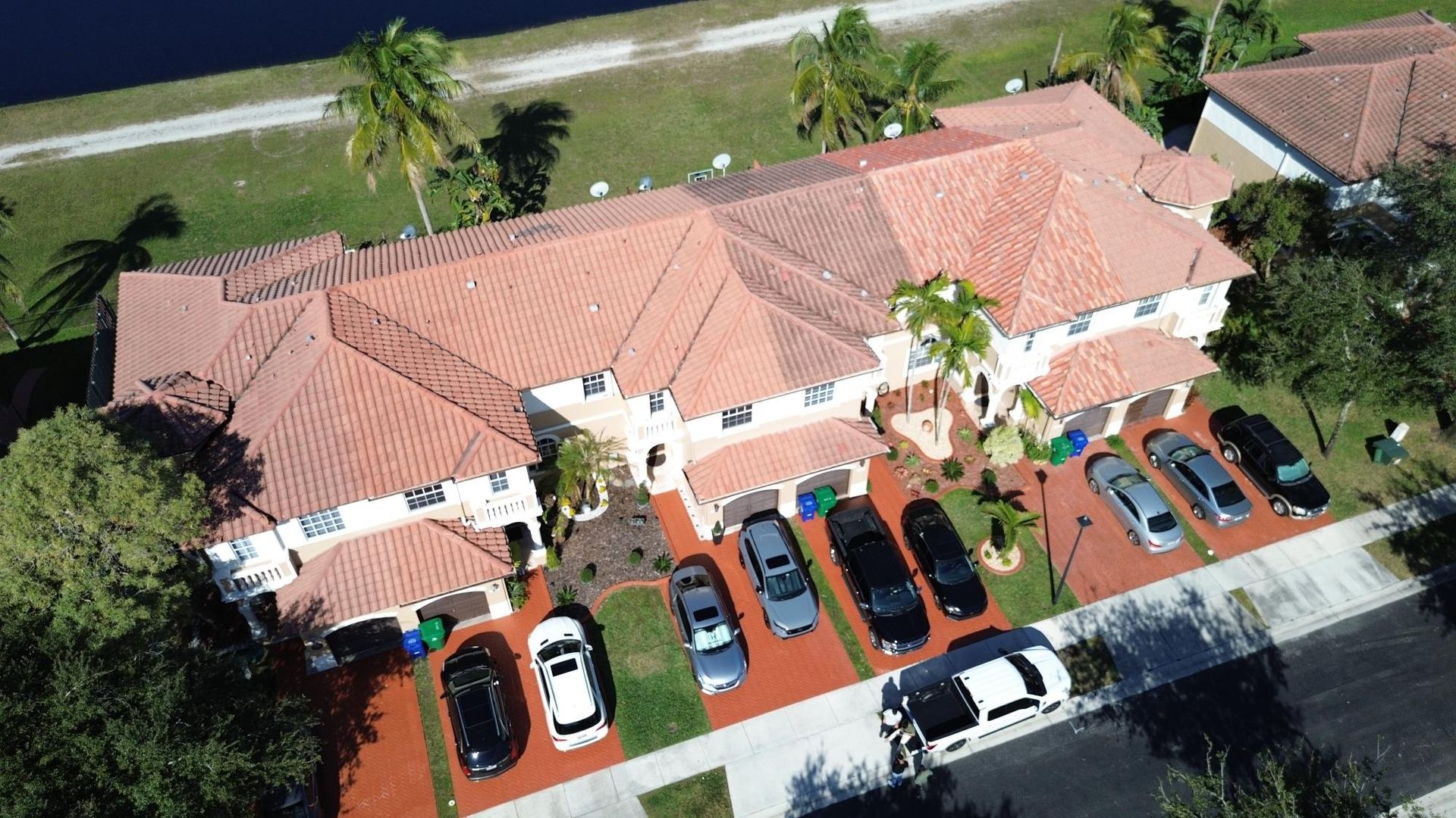 An aerial view of a house with cars parked in front of it