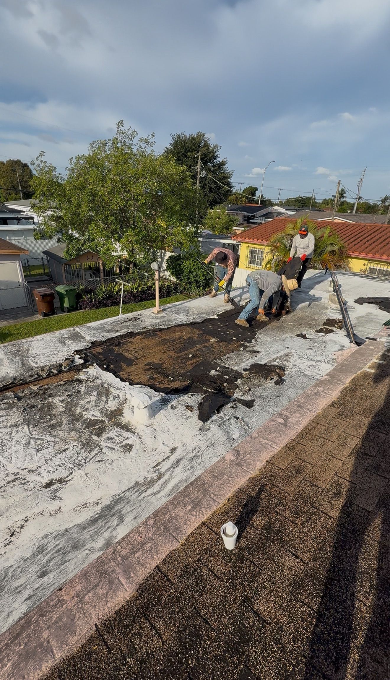A group of people are working on the roof of a house.