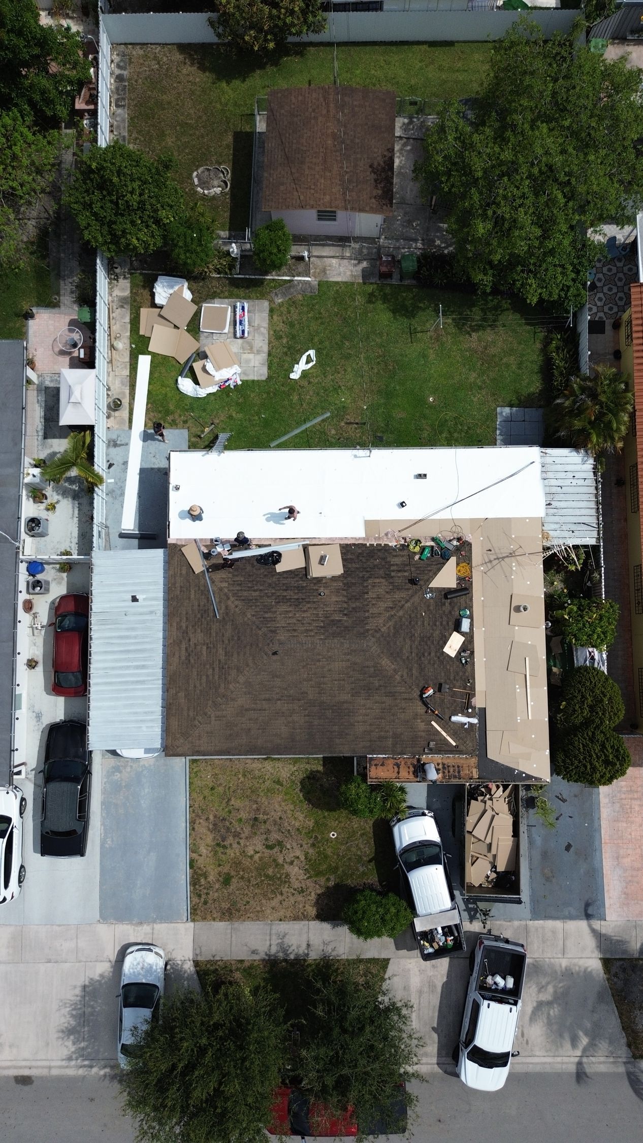 An aerial view of a house being remodeled with a white roof.