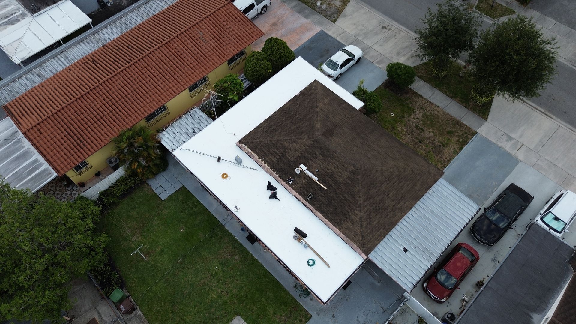 An aerial view of a house with a white roof