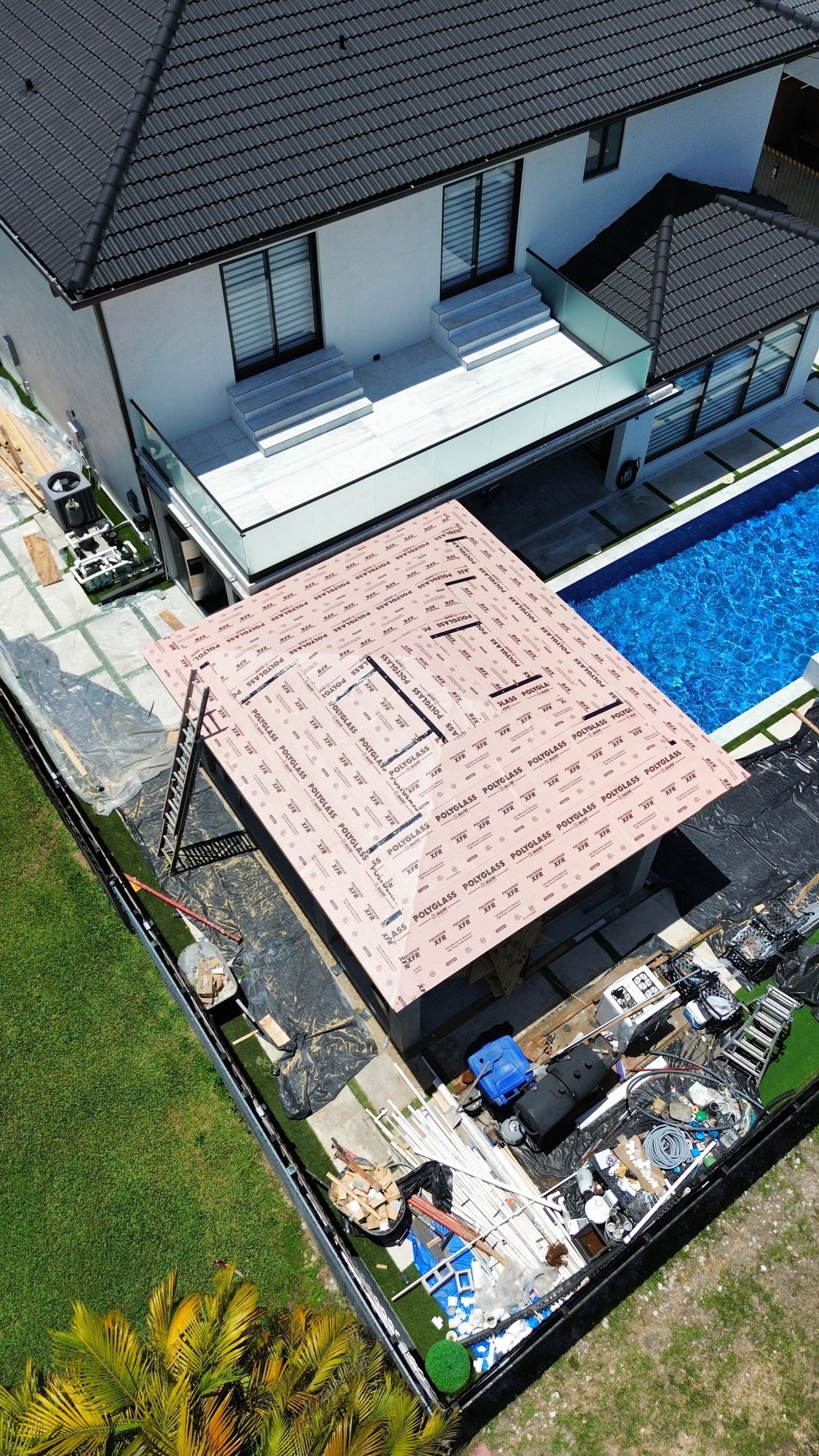 An aerial view of a house with a swimming pool in the backyard.