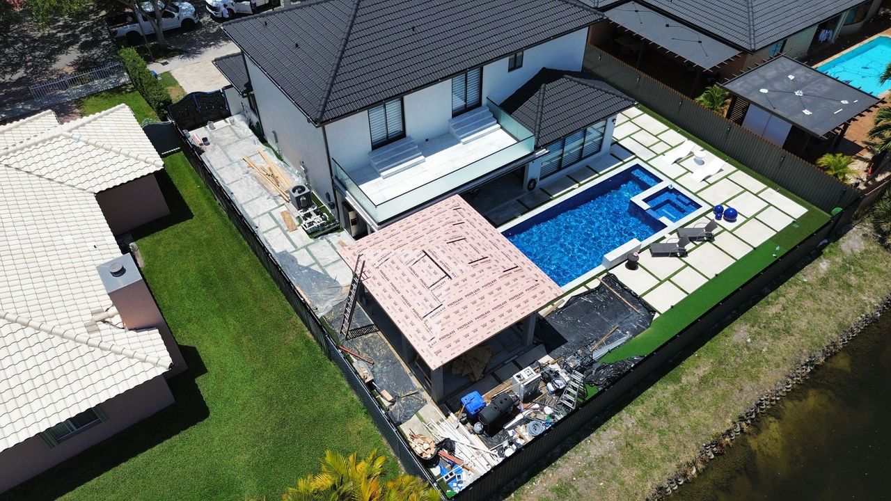 An aerial view of a house with a pool in the backyard.