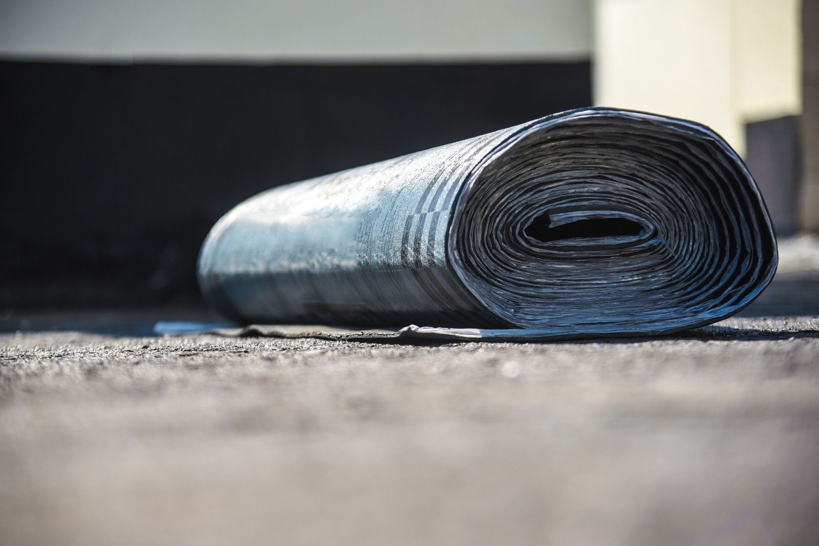 A roll of asphalt is laying on the ground.