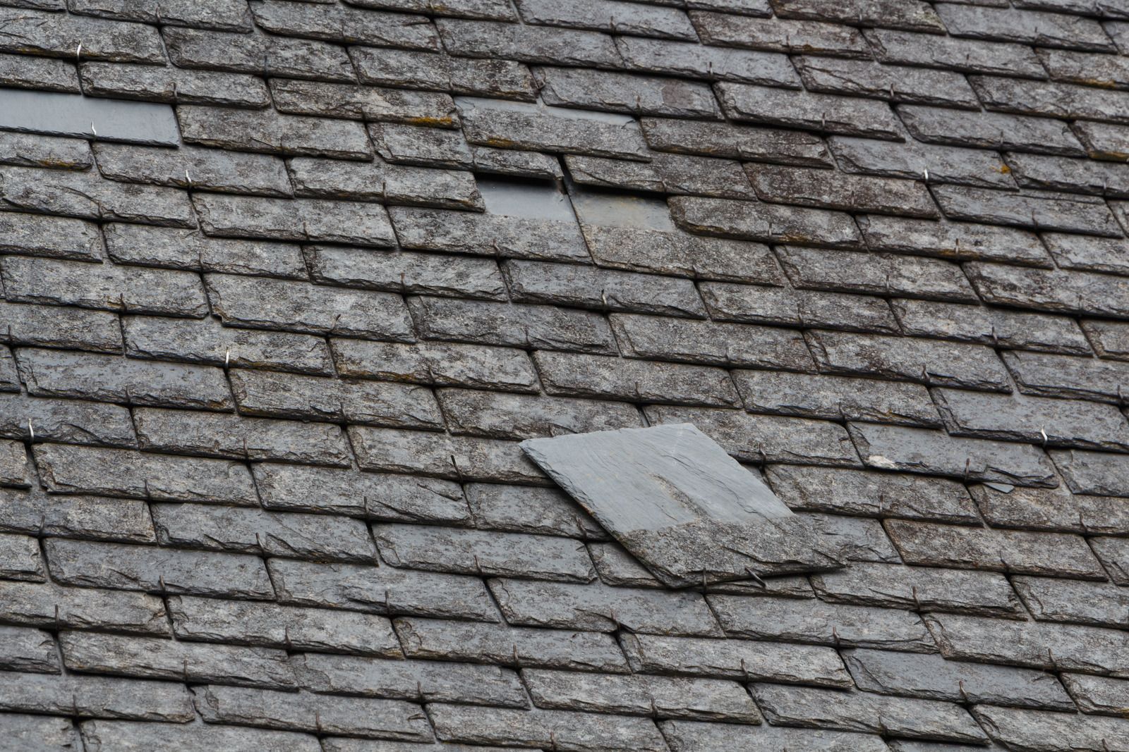 A close up of a roof with a broken tile