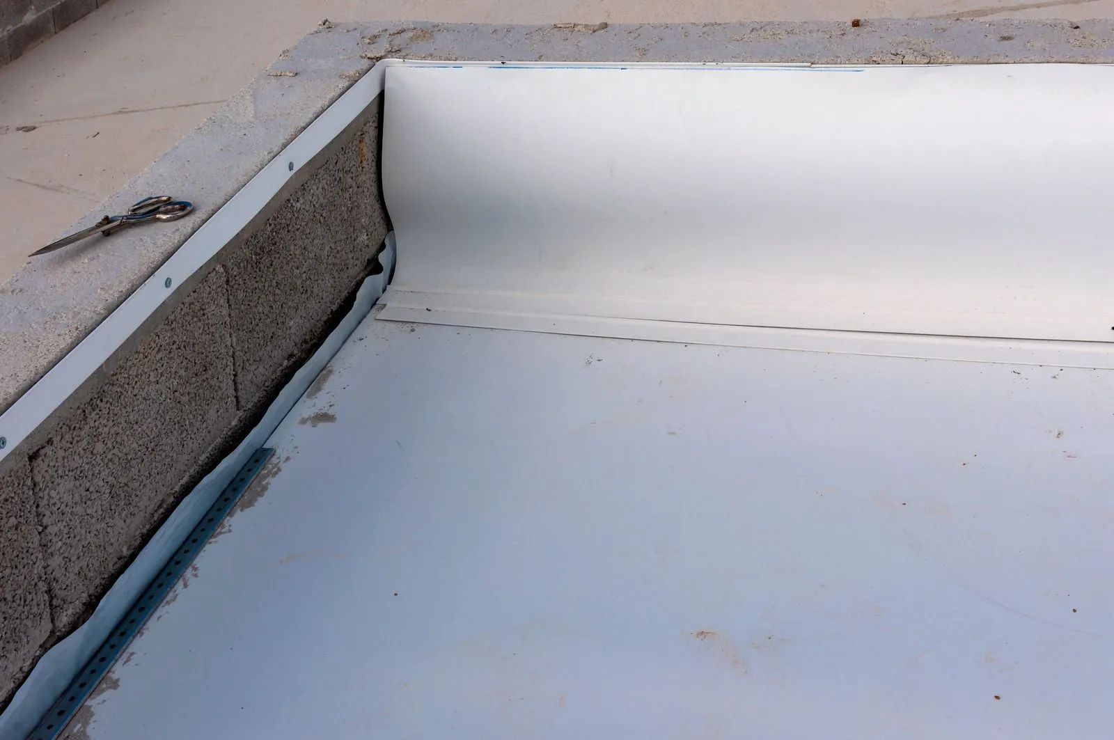 A close up of a metal roof with a concrete border.