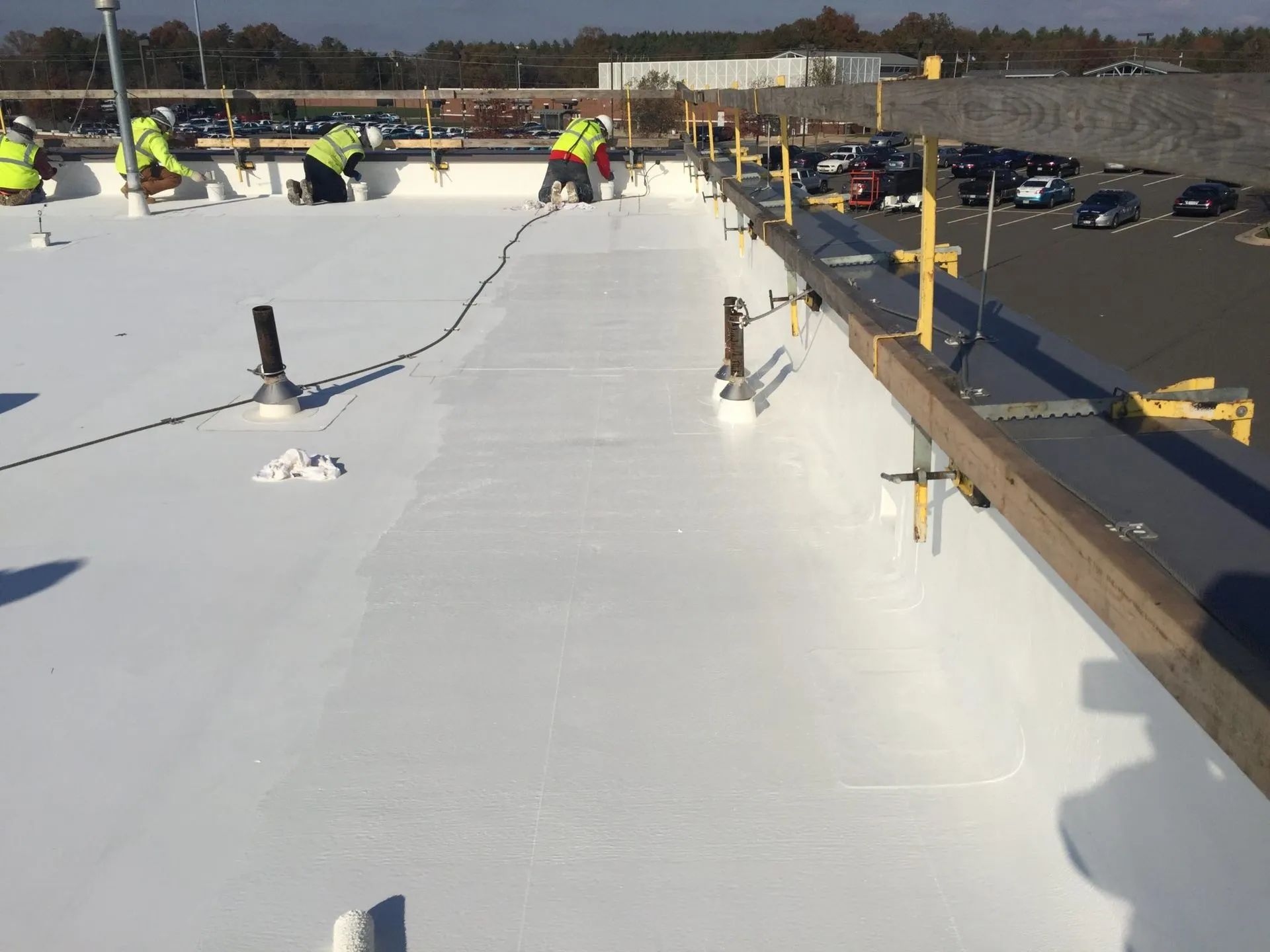 A group of people are working on a white roof.