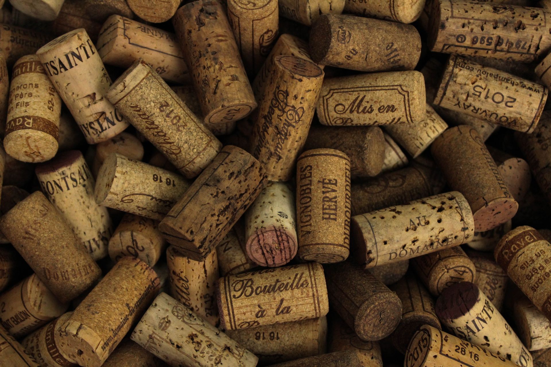Pile of used corks with various printed labels.