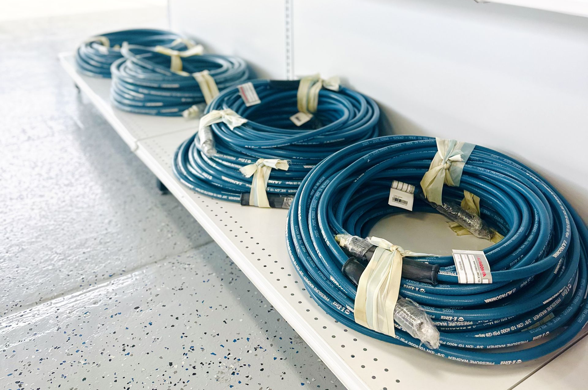 Coiled blue cables bundled on a white shelf in a bright indoor setting
