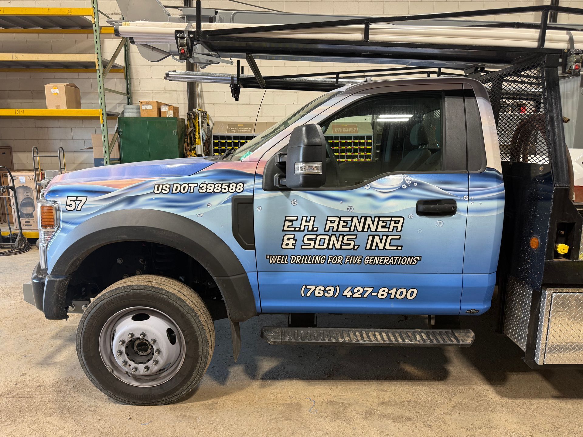 Side view of a blue and white work truck with 