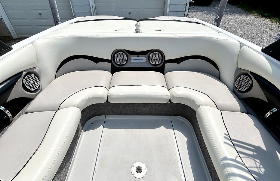 The back of a boat with a couch and speakers