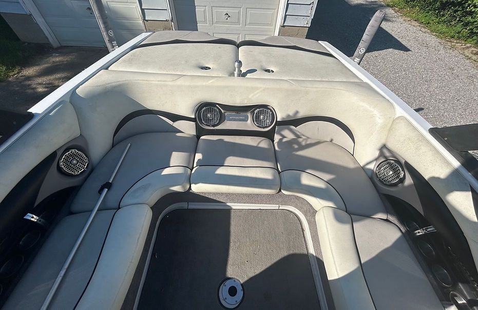 A boat is parked in a driveway next to a garage