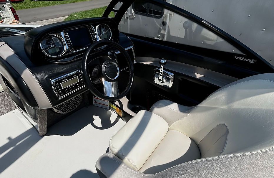 The inside of a boat with a steering wheel and dashboard