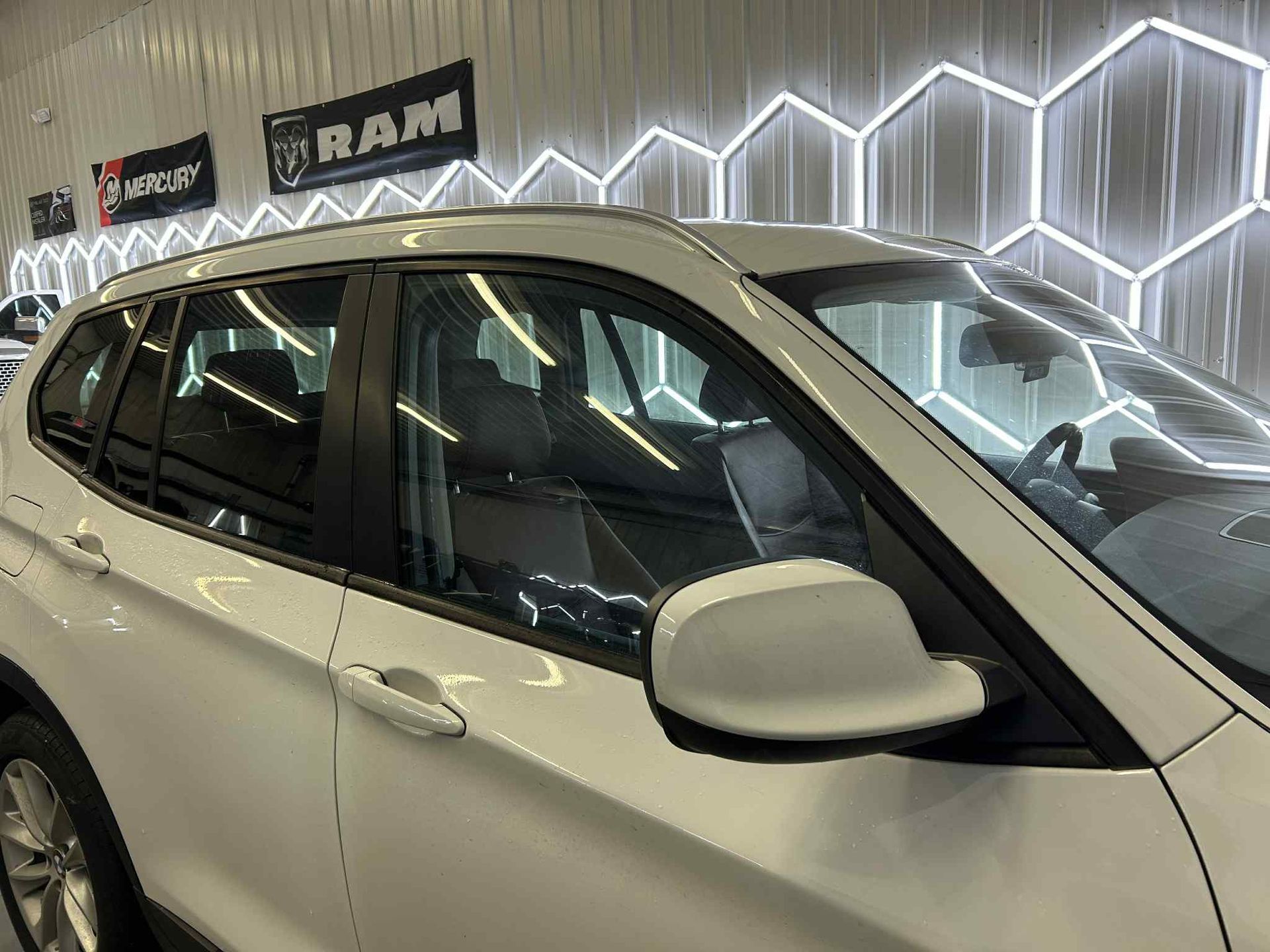 Gray Ford Expedition SUV in a car wash bay with hexagon-shaped neon lights.