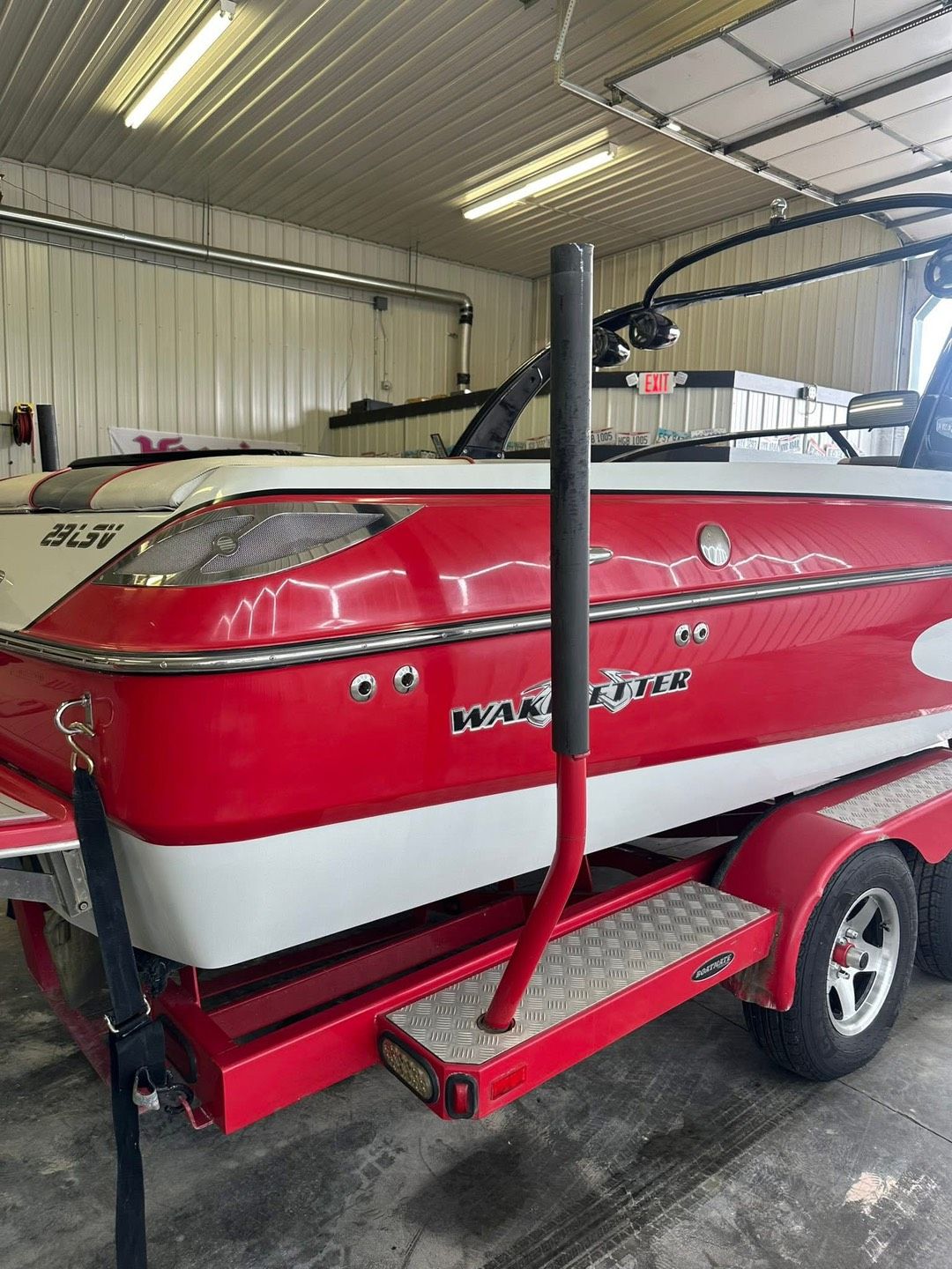 A boat is parked in front of a garage on a sunny day