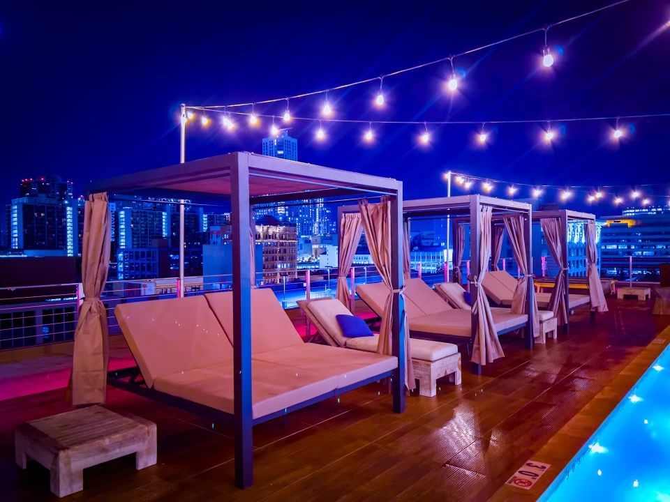 Rooftop pool deck at night with cabanas at HWH Luxury Living in DTLA