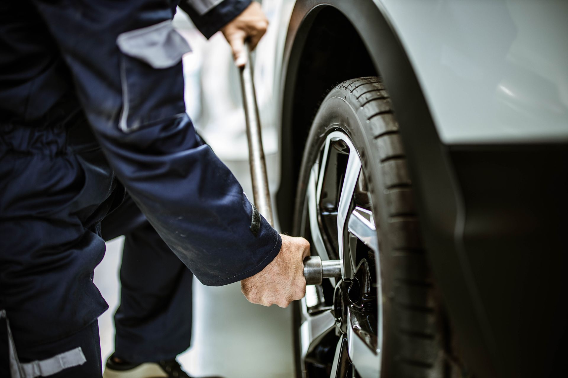 A repairman changing a wheel and tyre in a workshop