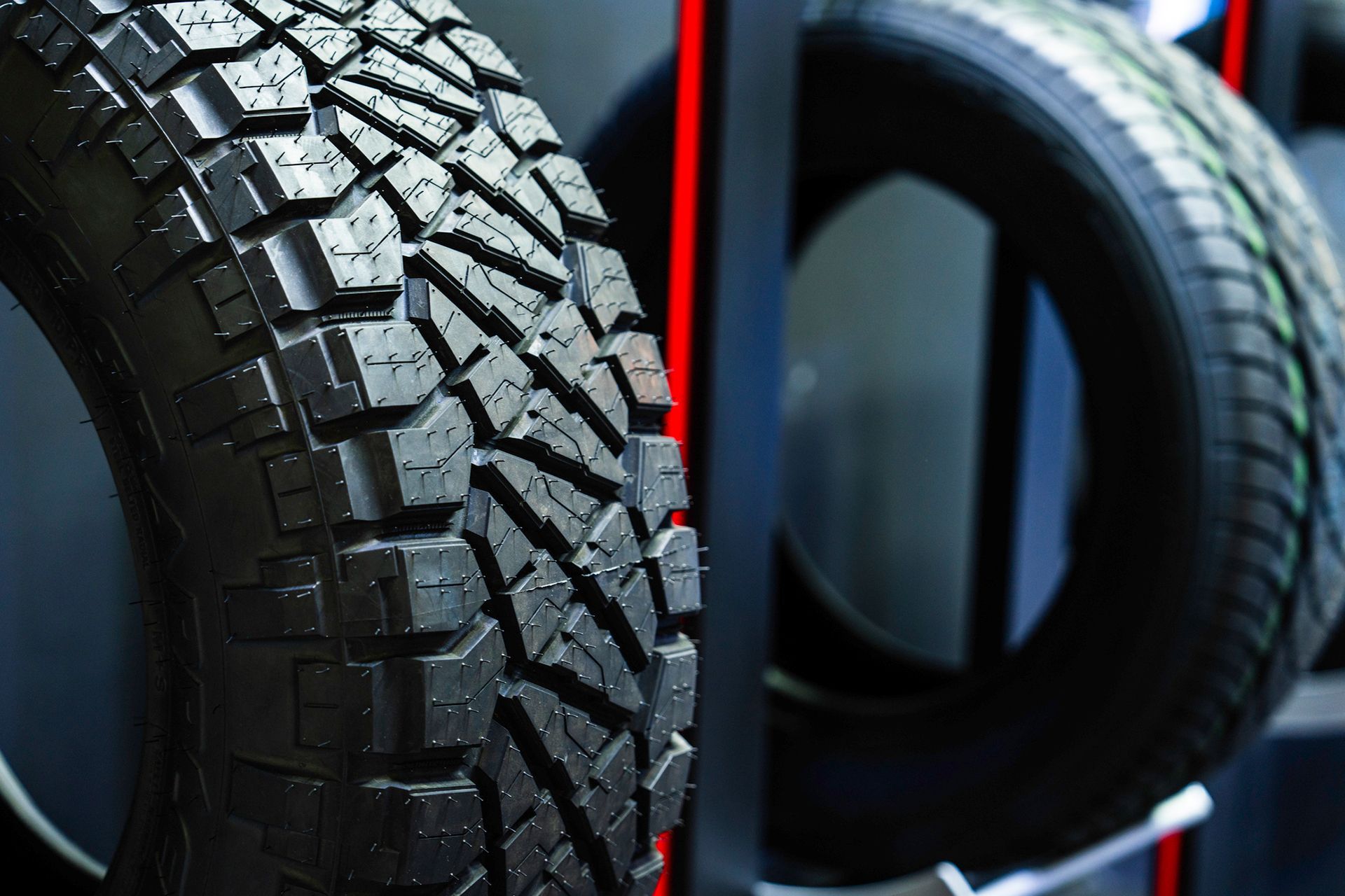 Close-up of rugged off-road tire with another tire in the background. Close-up of rugged off-road tire with another tire in the background.