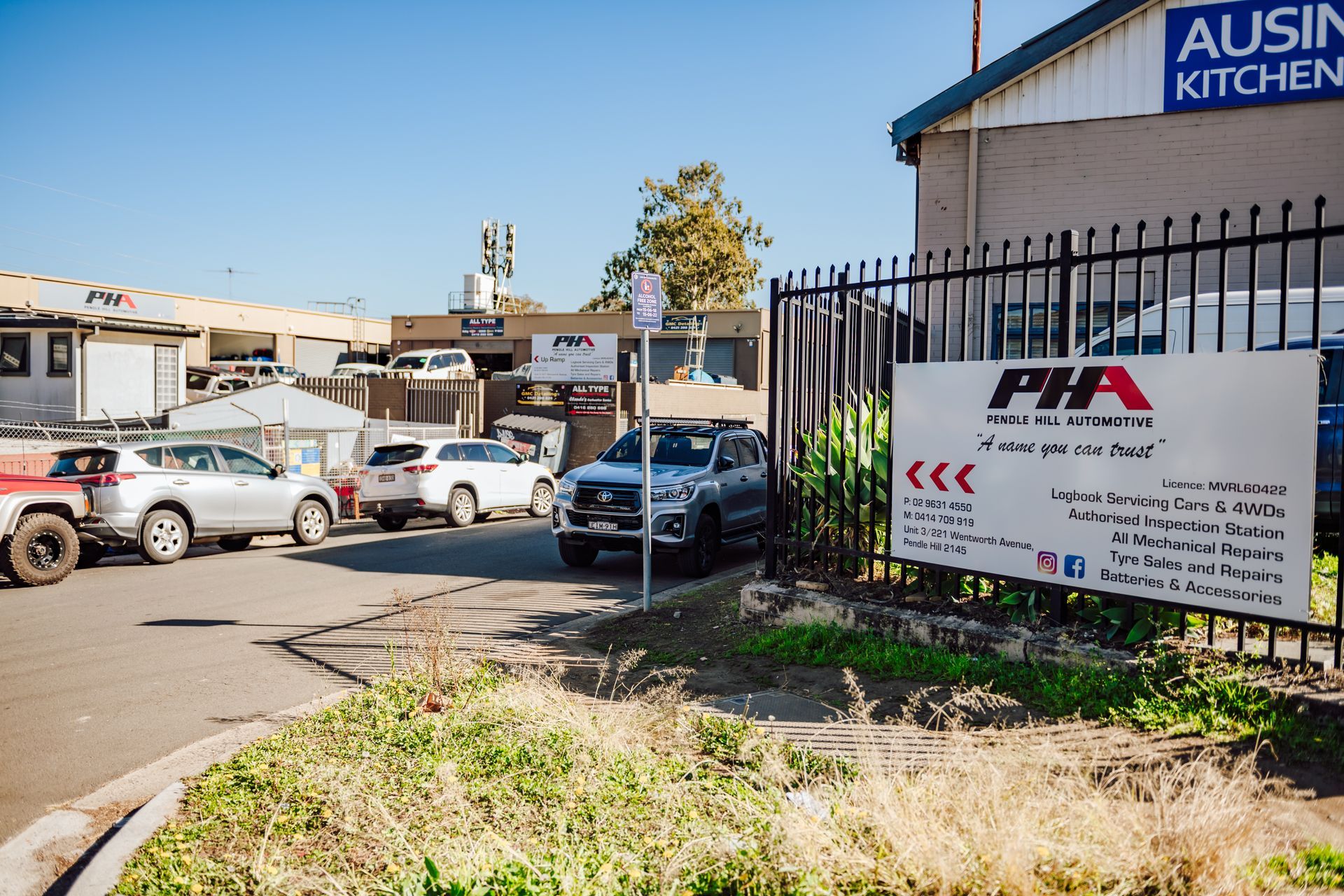 Cars parked outside a business with a sign that reads 