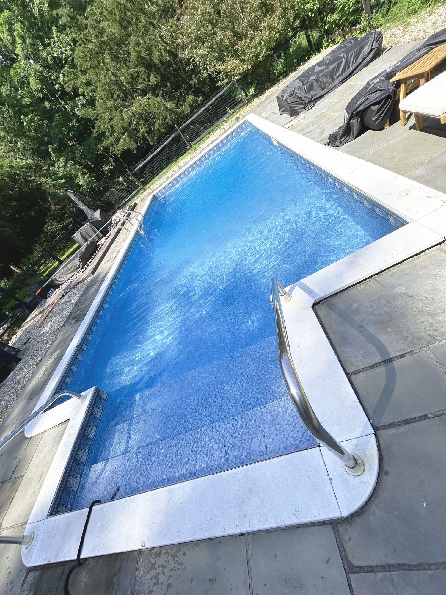 a large swimming pool with a staircase leading to it