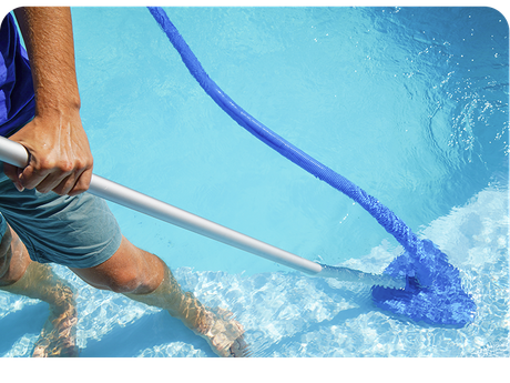 a man is cleaning a swimming pool with a broom .