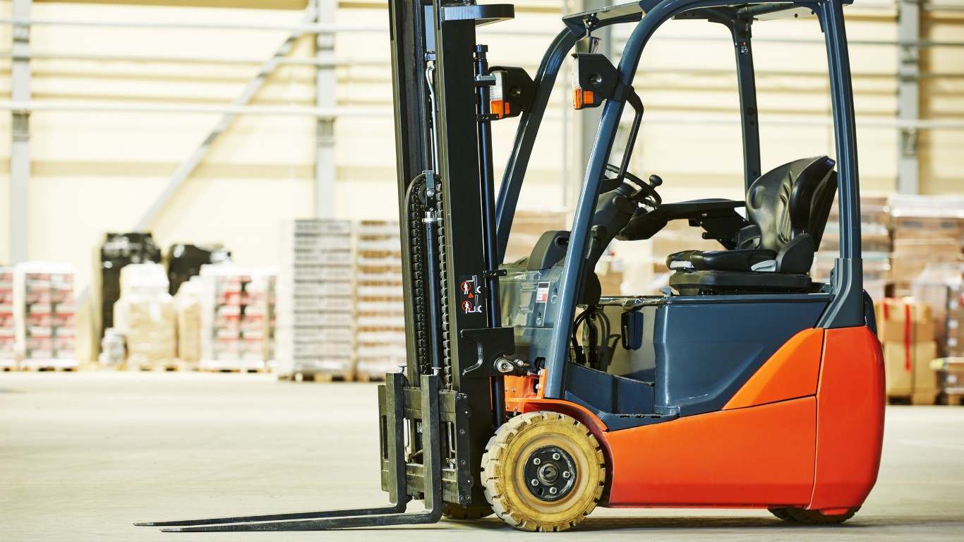Orange and blue forklift in a warehouse, ready for operation.