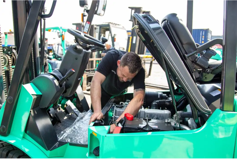 Forklift operator in orange suit transports debris on a city street.