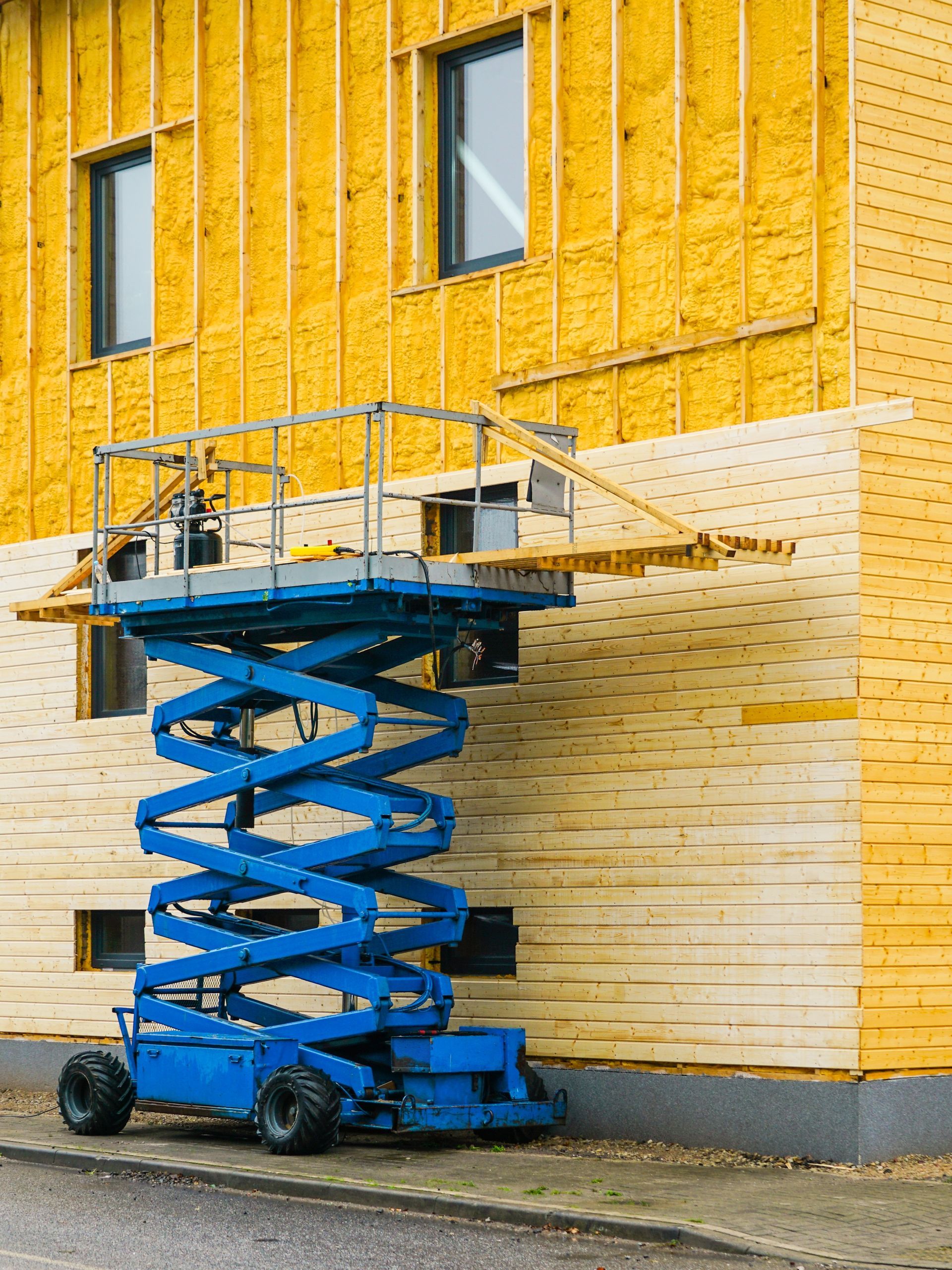 Construction cranes silhouetted against a colorful sunset sky.