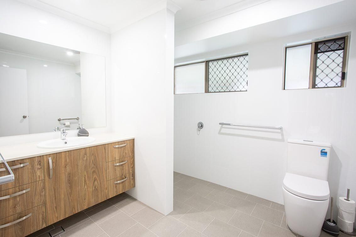A Bathroom with A Toilet, Sink and Mirror — Caldera Kitchens and Bathrooms in Lynchs Creek, NSW