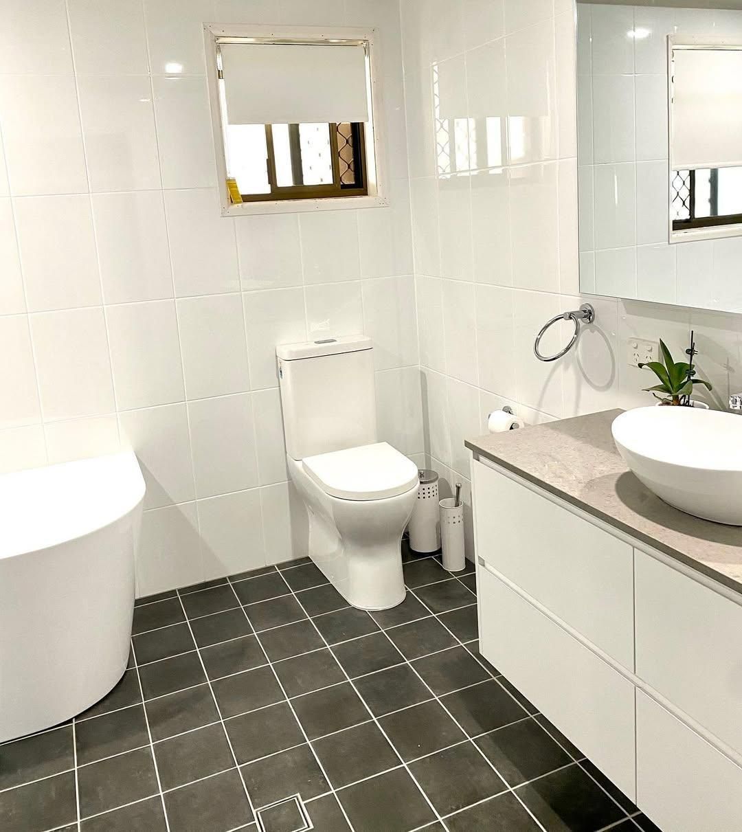 A Bathroom with A Toilet, Sink, Tub and Mirror — Caldera Kitchens and Bathrooms in Lynchs Creek, NSW