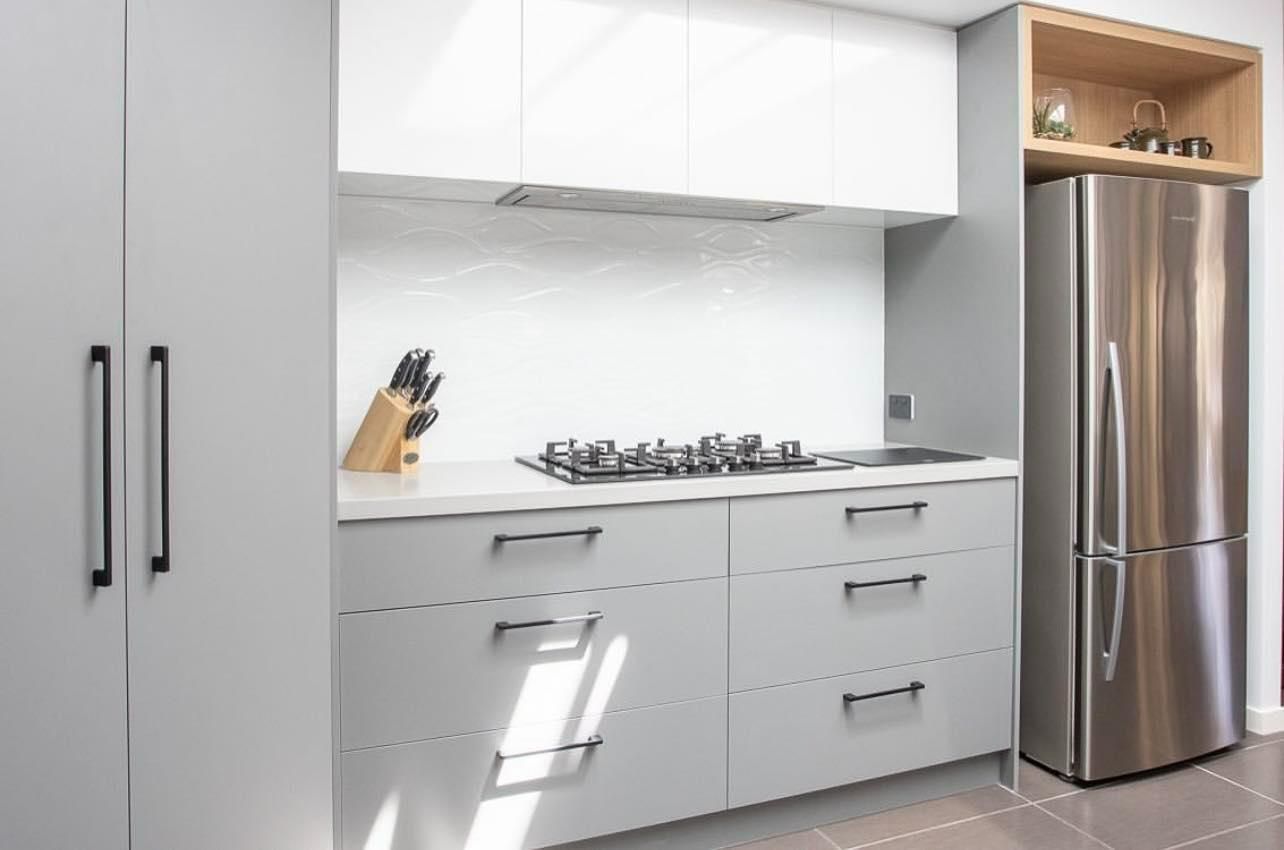 A Kitchen with White Cabinets and A Stainless Steel Refrigerator — Caldera Kitchens and Bathrooms in Lynchs Creek, NSW