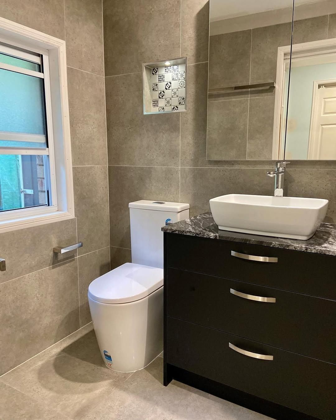 A Bathroom with A Toilet, Sink and Mirror — Caldera Kitchens and Bathrooms in Lynchs Creek, NSW