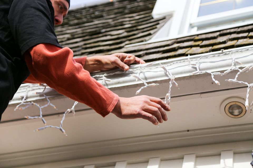 hanging lights on roof during the Holidays