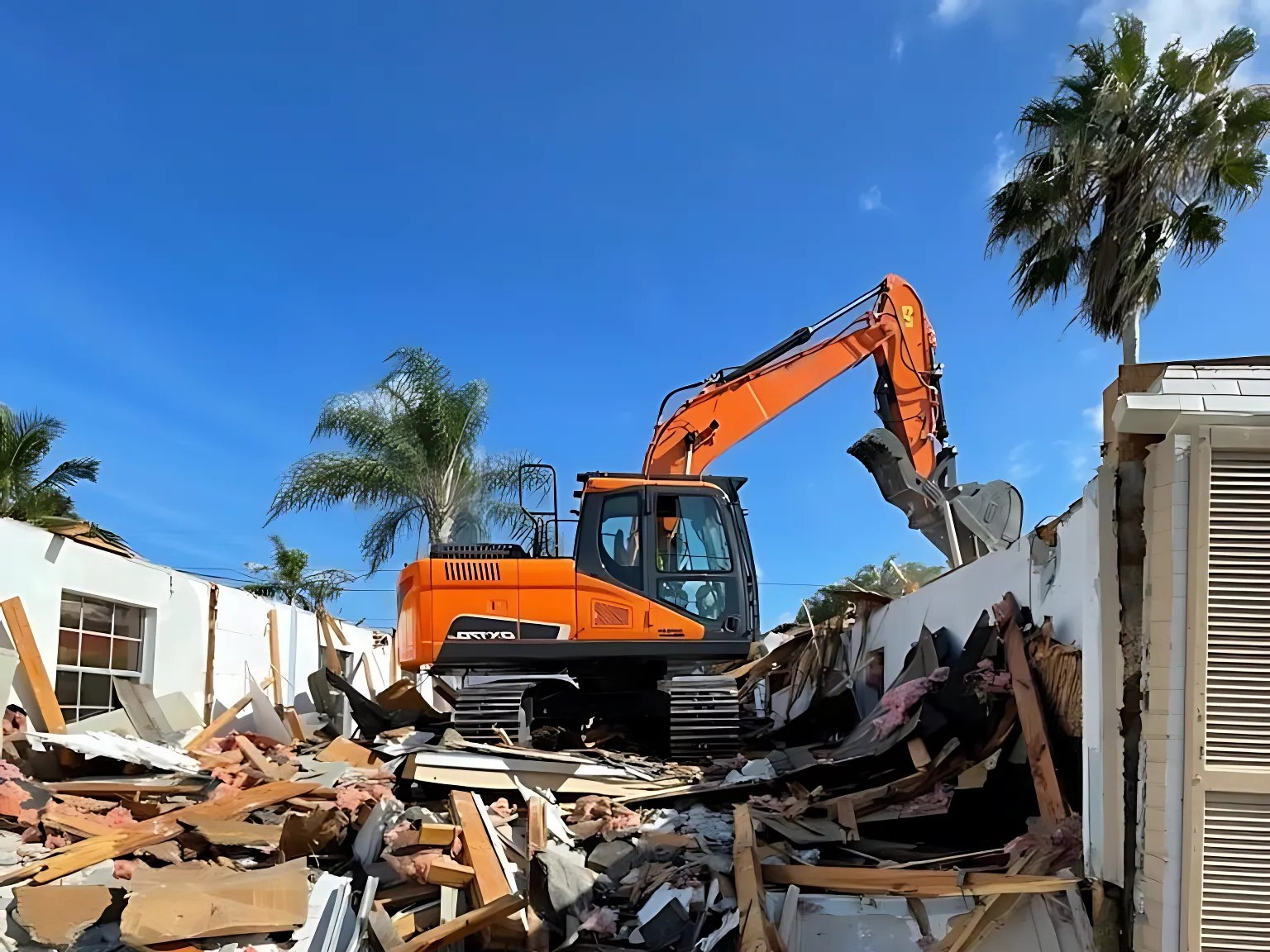 An excavator in Port St Lucie, Fl, is tearing through the roof and walls of a structure in a commercial demolition project.