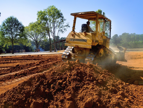 A bulldozer in action at a land clearing site.