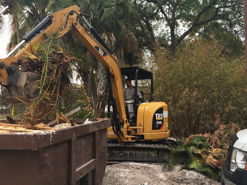 A mini excavator working at a small residential excavation site.